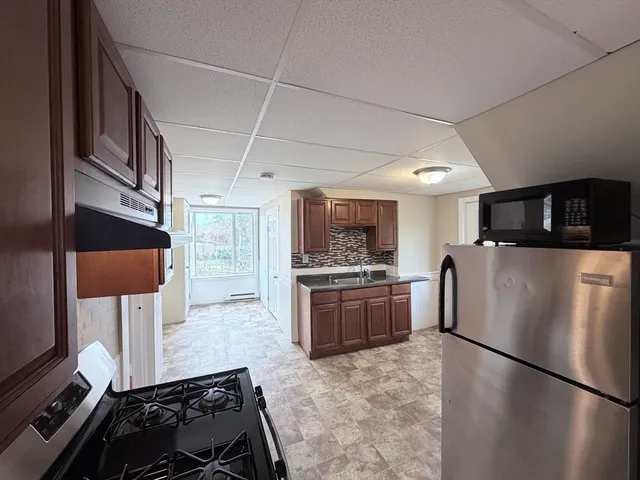 a kitchen with stainless steel appliances granite countertop a refrigerator and a stove