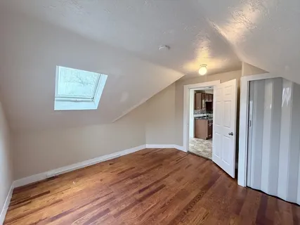 a view of empty room with wooden floor