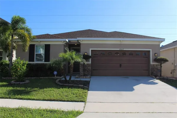 a front view of a house with a yard and garage