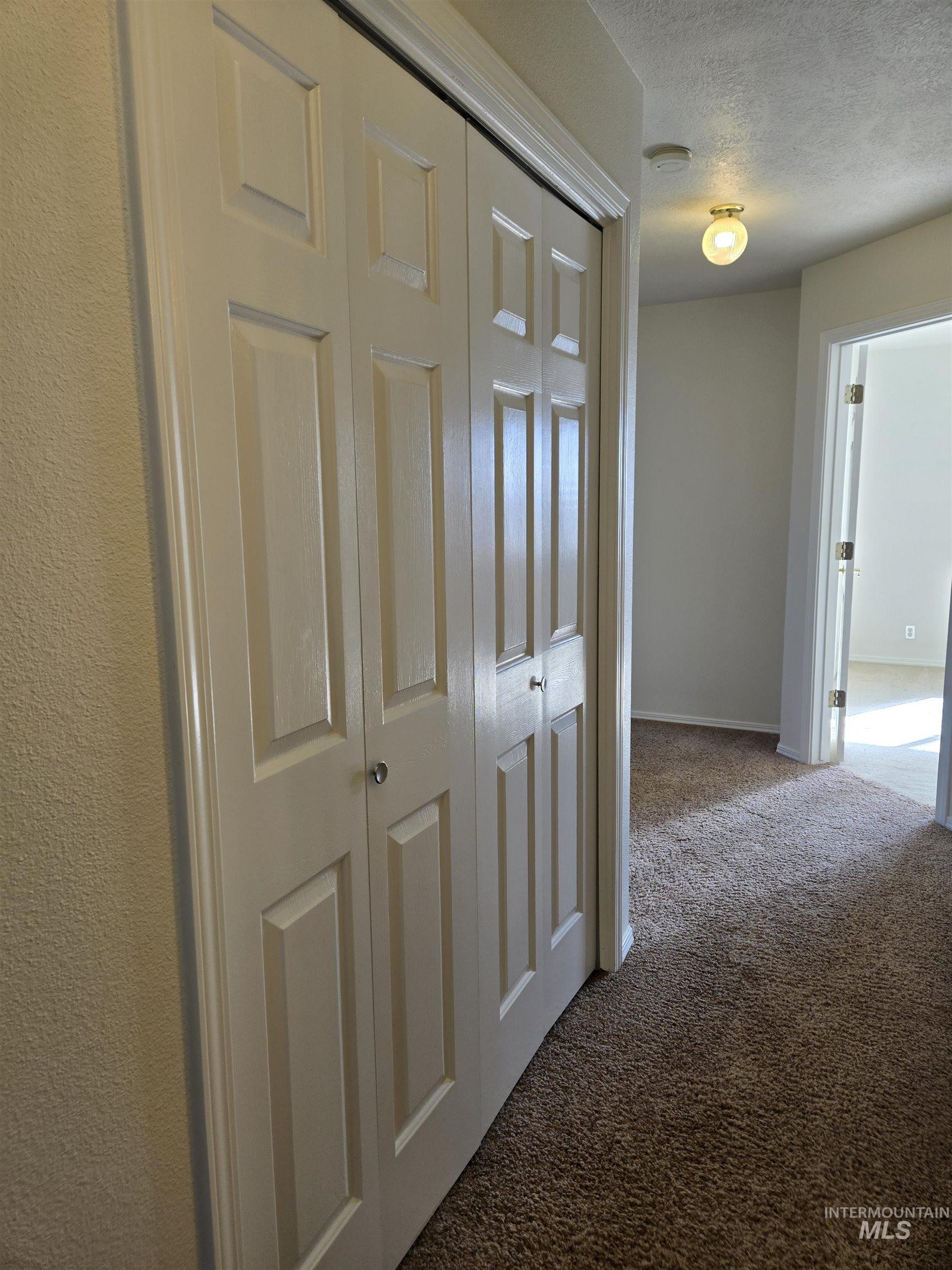 183 Southwest 18th Street Ontario, OR 97914 - Photo 16 of 32 Hallway with carpet floors and a textured ceiling