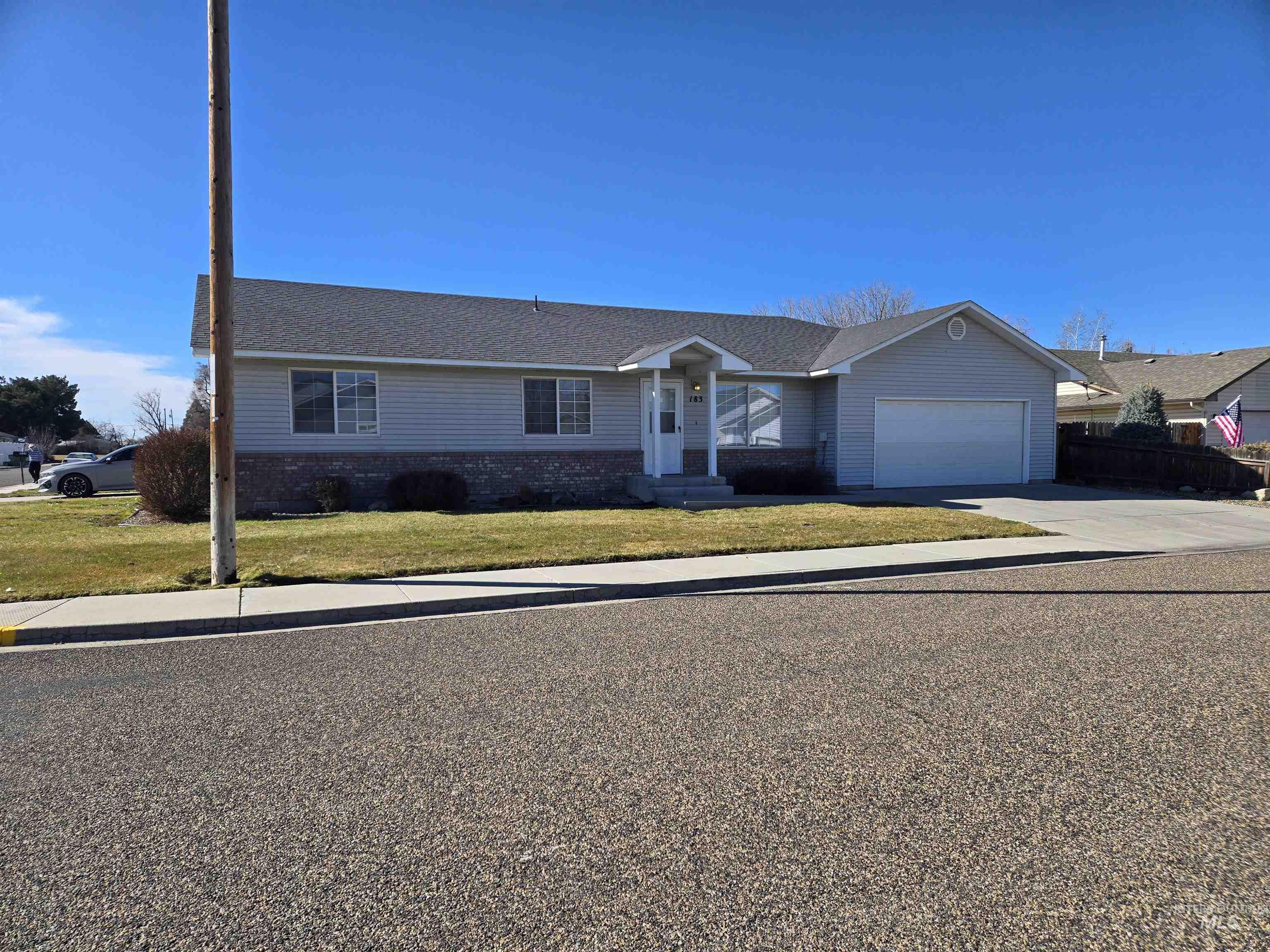 183 Southwest 18th Street Ontario, OR 97914 - Photo 2 of 32 Single story home featuring concrete driveway, a front lawn, an attached garage, and brick siding