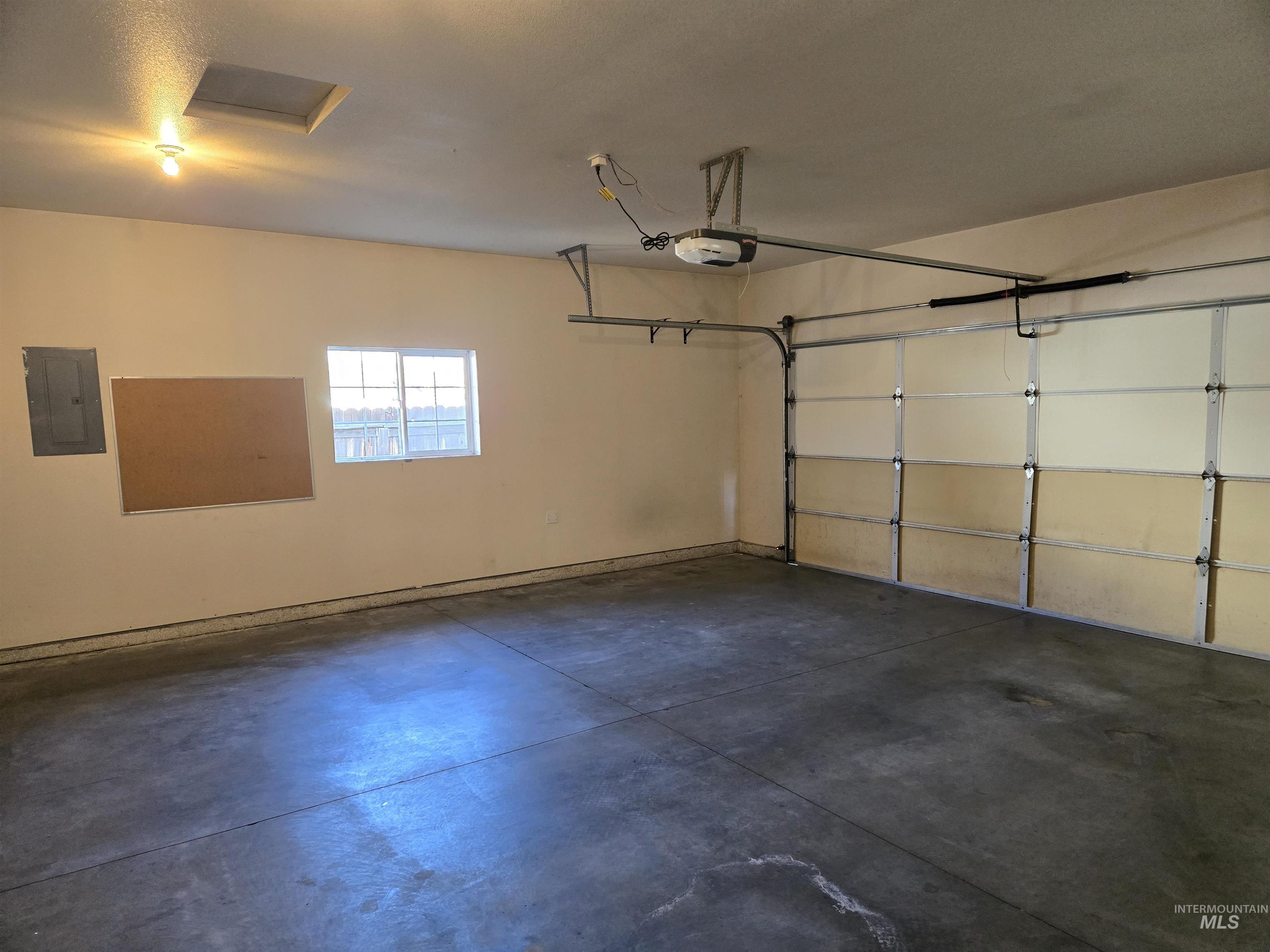 183 Southwest 18th Street Ontario, OR 97914 - Photo 31 of 32 Garage with electric panel and a garage door opener