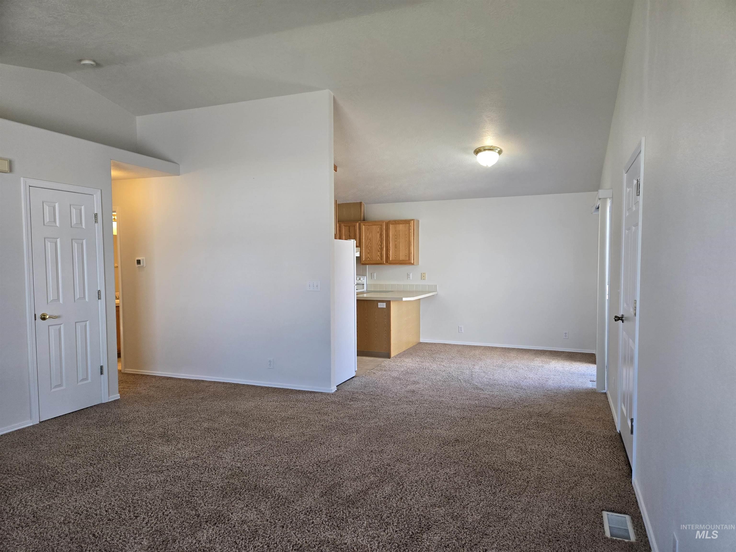 183 Southwest 18th Street Ontario, OR 97914 - Photo 6 of 32 Unfurnished living room featuring light colored carpet and lofted ceiling