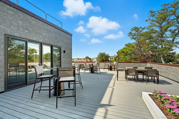 a balcony with wooden floor table and chairs