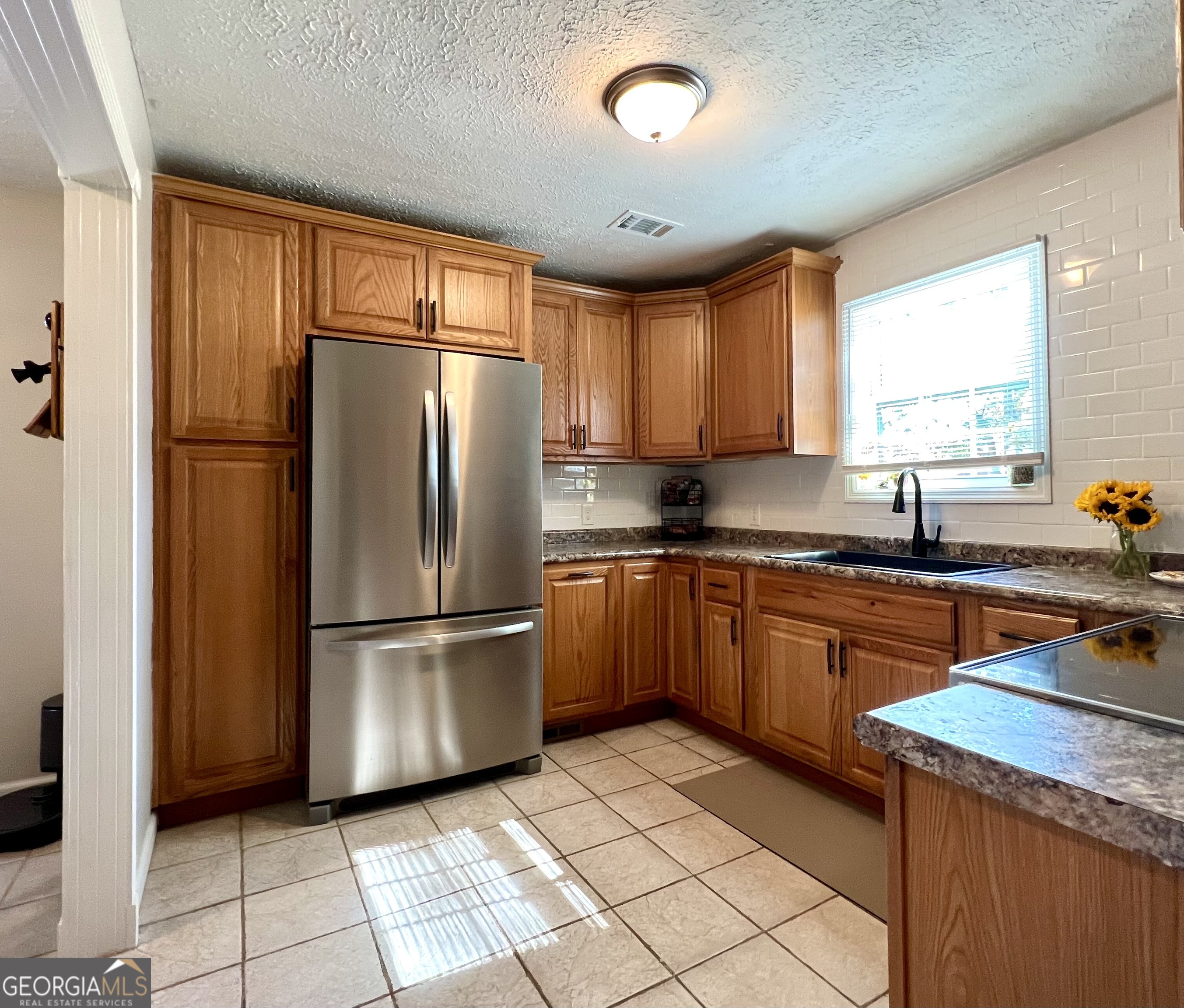 554 Spring Street Commerce, GA 30529 - Photo 15 of 58 a kitchen with stainless steel appliances granite countertop a refrigerator sink and cabinets