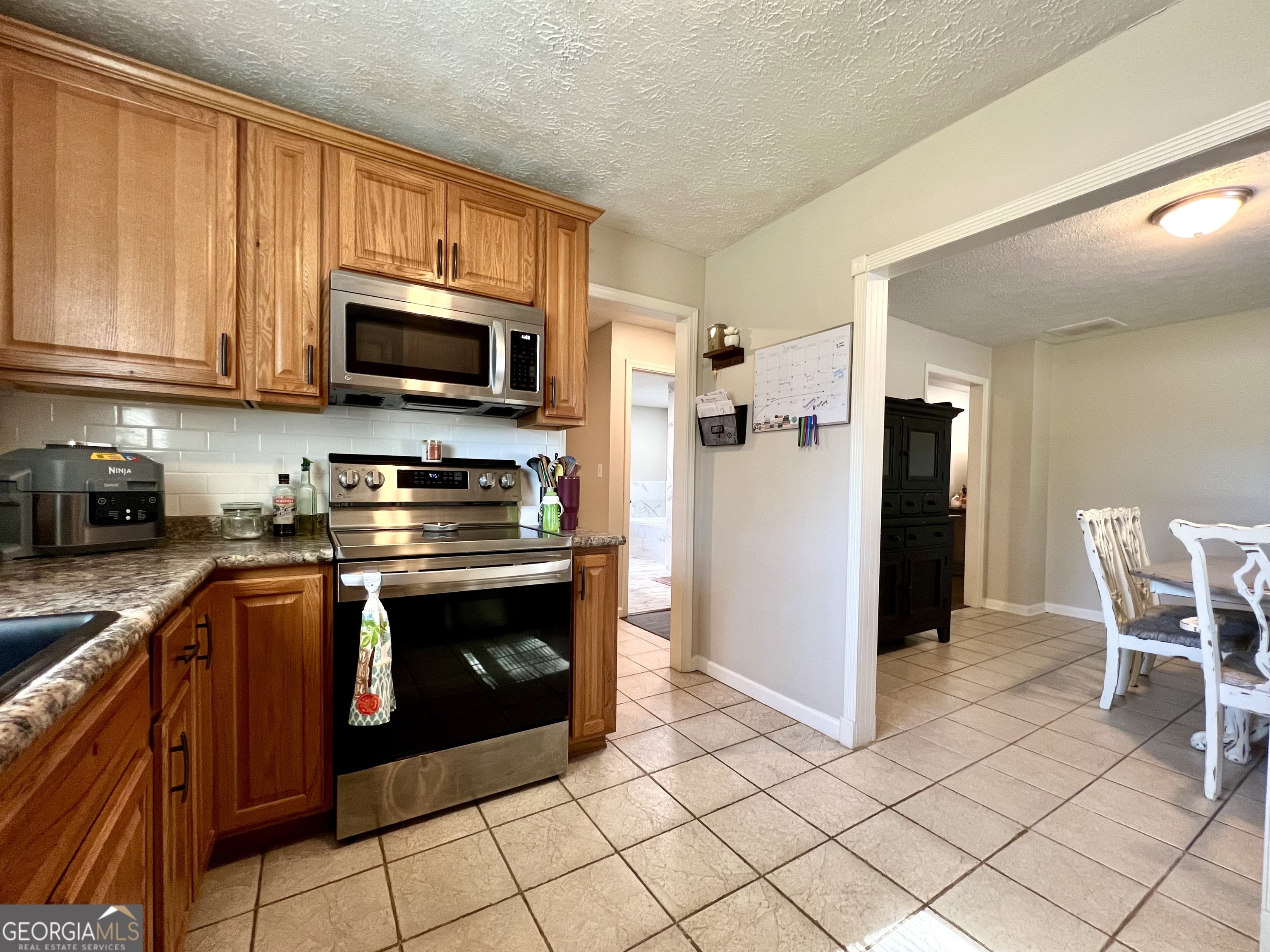 554 Spring Street Commerce, GA 30529 - Photo 16 of 58 a kitchen with stainless steel appliances granite countertop a stove a sink and a microwave