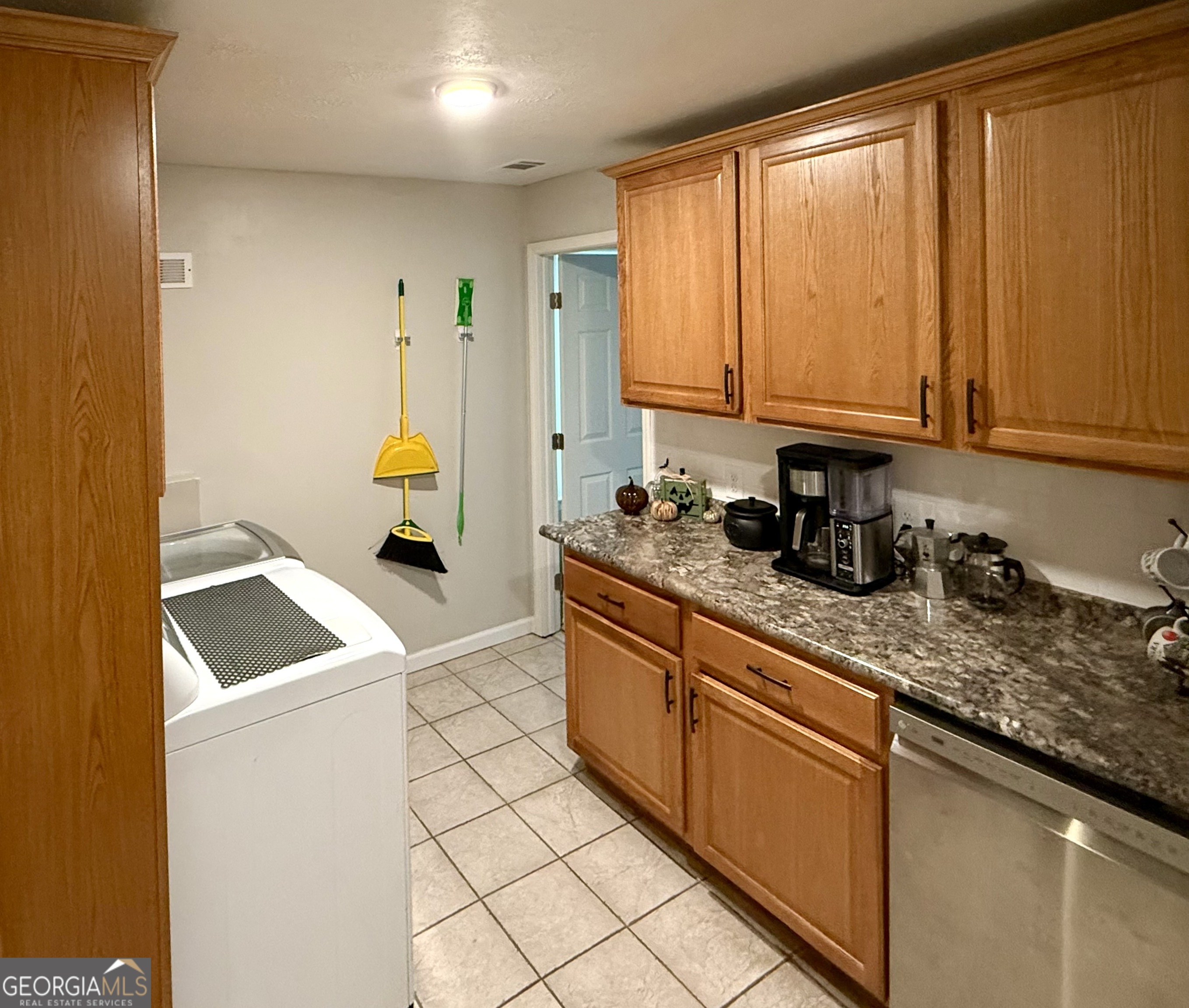 554 Spring Street Commerce, GA 30529 - Photo 18 of 58 a kitchen with stainless steel appliances granite countertop a sink a stove and white cabinets