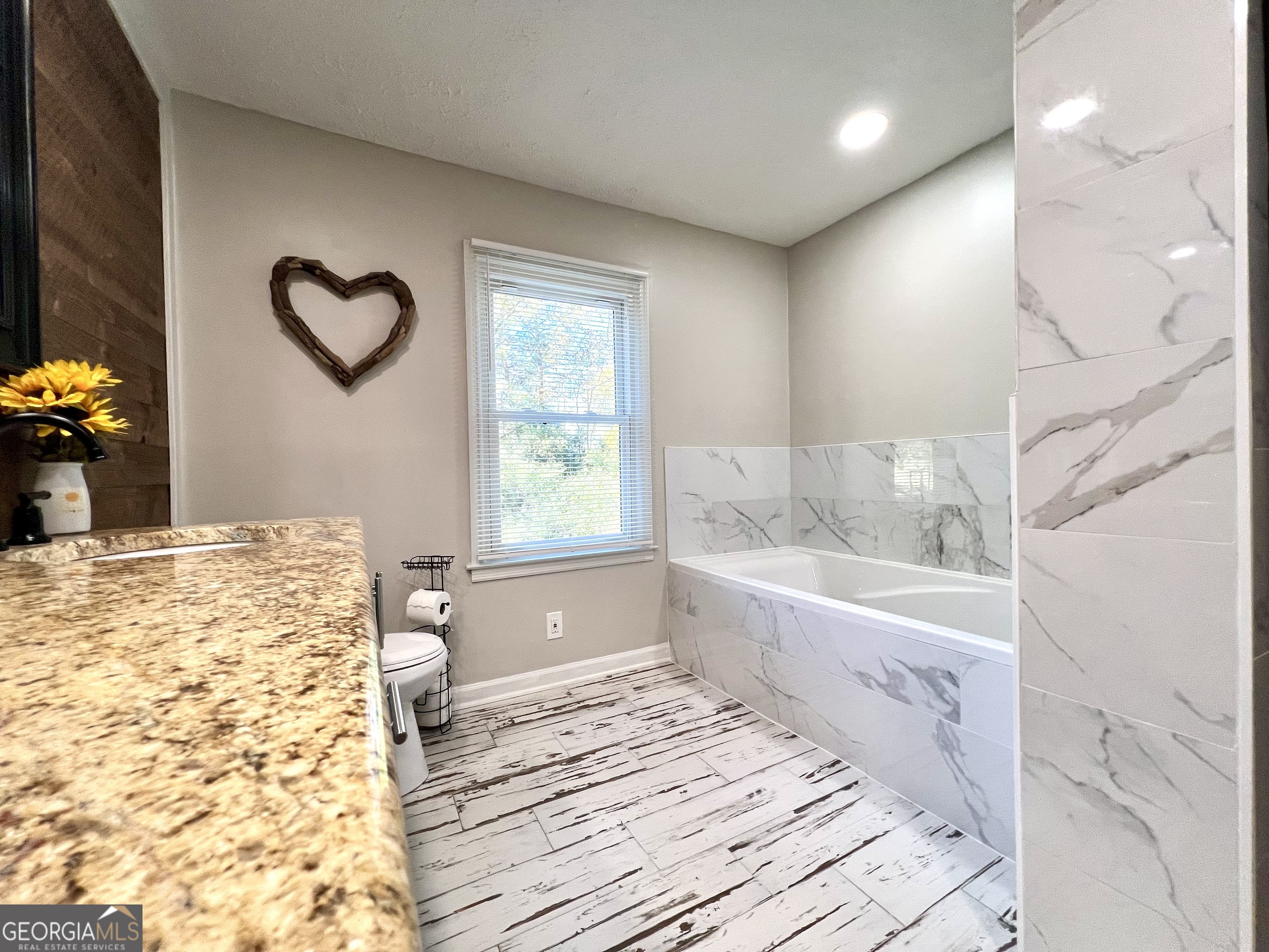 554 Spring Street Commerce, GA 30529 - Photo 29 of 58 a bathroom with a bathtub and a shower