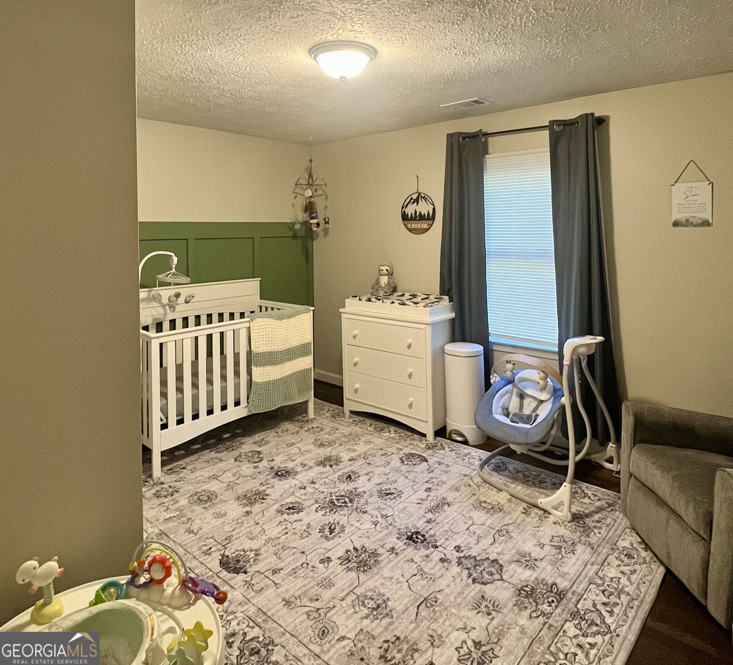 554 Spring Street Commerce, GA 30529 - Photo 36 of 58 a room with a baby bed a couch and dresser