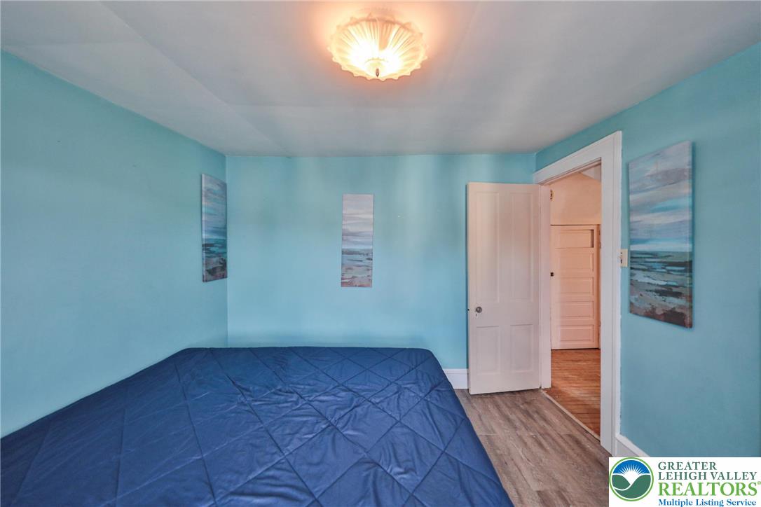 417 3rd Street Lehighton, PA 18235 - Photo 22 of 39 This tranquil bedroom offers durable plank flooring and a classic paneled door leading to another area.