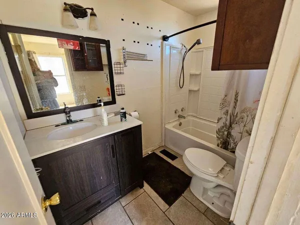 a bathroom with a sink a toilet a mirror and shower