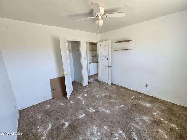 en empty room with windows and fan