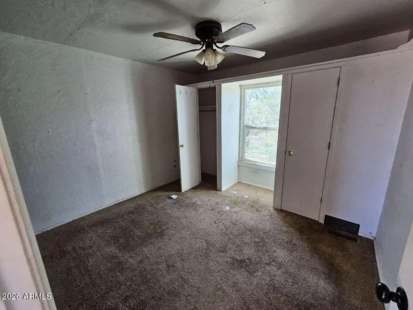 a view of a livingroom with a ceiling fan and window