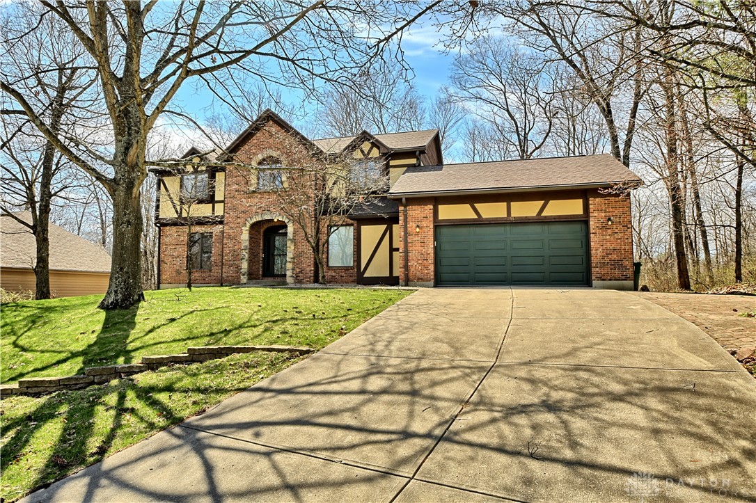 8711 Nicole Lane Springboro, OH 45066 - Photo 2 of 87 Brick facade with timber detailing, this residence features a concrete driveway leading to an attached garage.