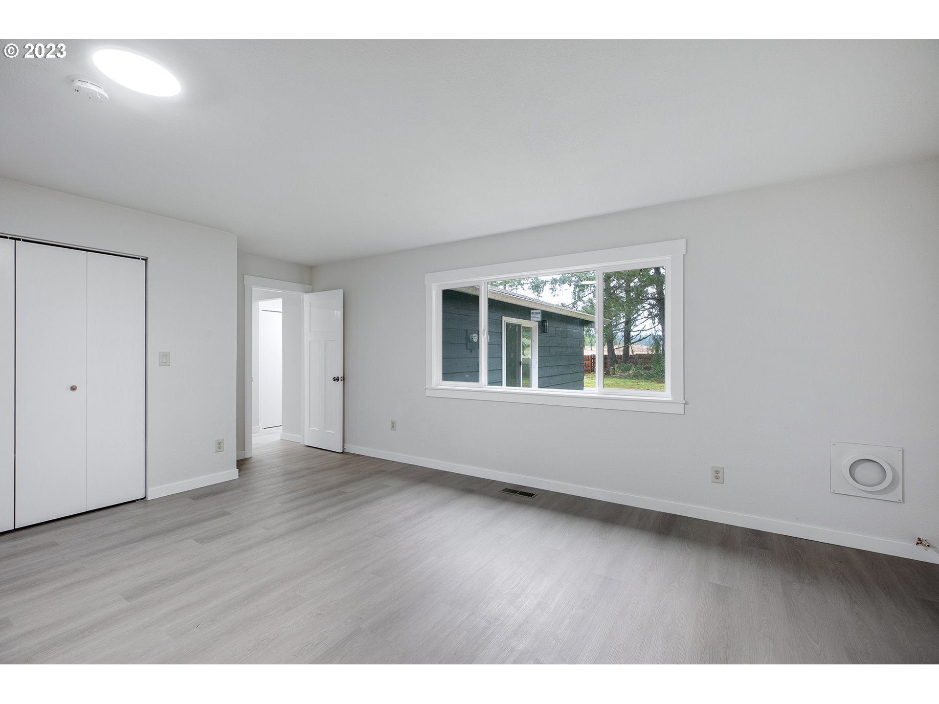 25331 South Larkin Road Beavercreek, OR 97004 - Photo 30 of 44 a view of an empty room with wooden floor and windows