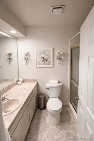 a bathroom with a granite countertop toilet a sink and a mirror