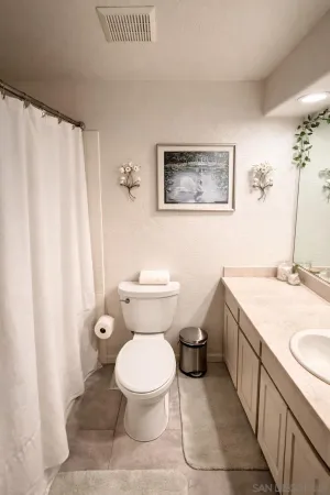 a bathroom with a granite countertop toilet a sink and a mirror