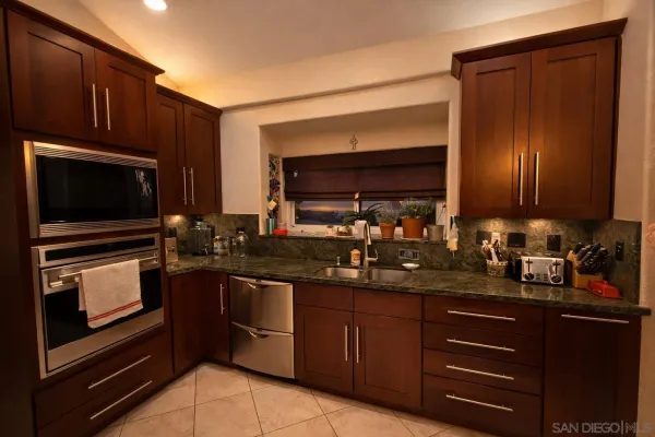 a kitchen with sink a microwave a stove and cabinets