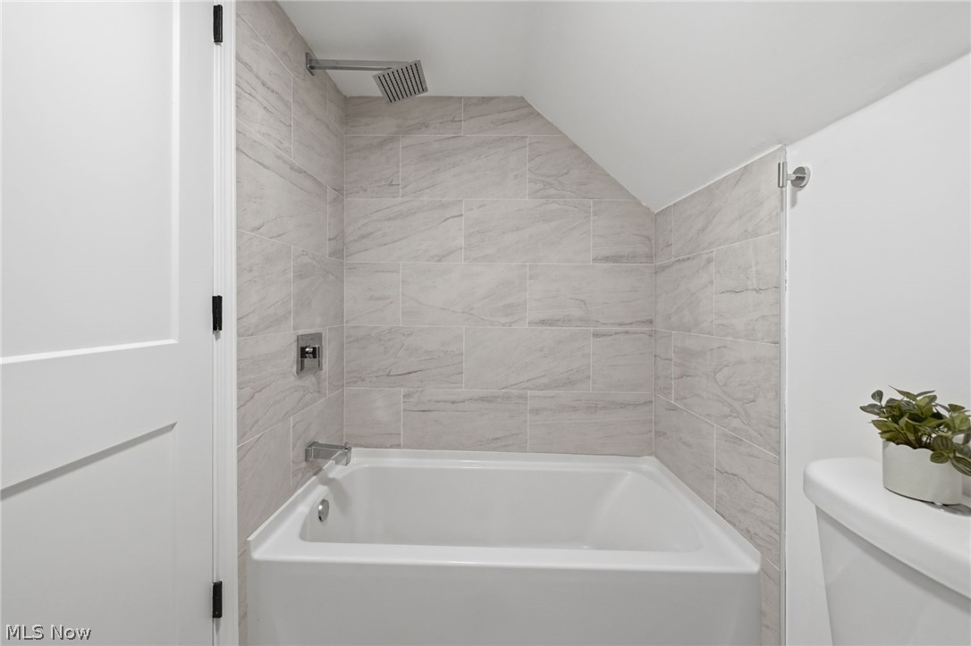 951 Bey Road Akron, OH 44312 - Photo 20 of 34 Second floor bathtub and shower combination featuring large format tile surround, a rain shower head, and polished chrome fixtures
