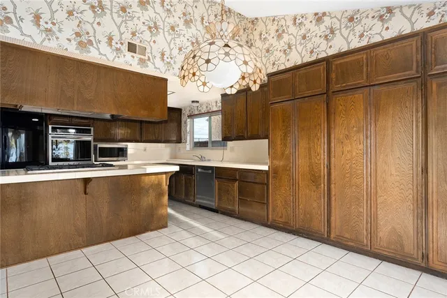 a living room with stainless steel appliances kitchen island granite countertop a refrigerator and a stove top oven