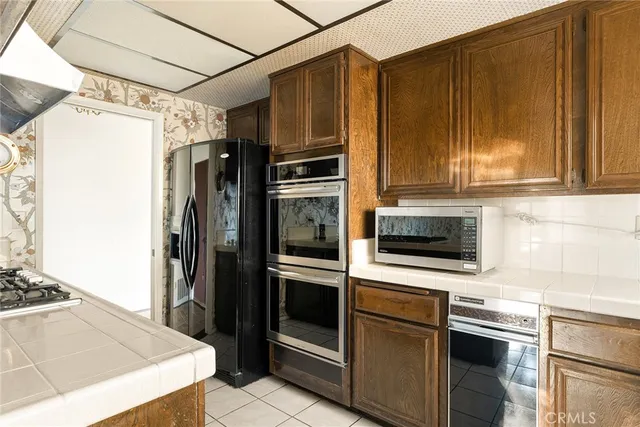 a kitchen with stainless steel appliances kitchen island granite countertop a refrigerator stove and sink