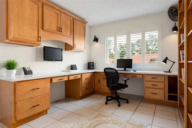 a view of workspace with wooden floor and white cabinets