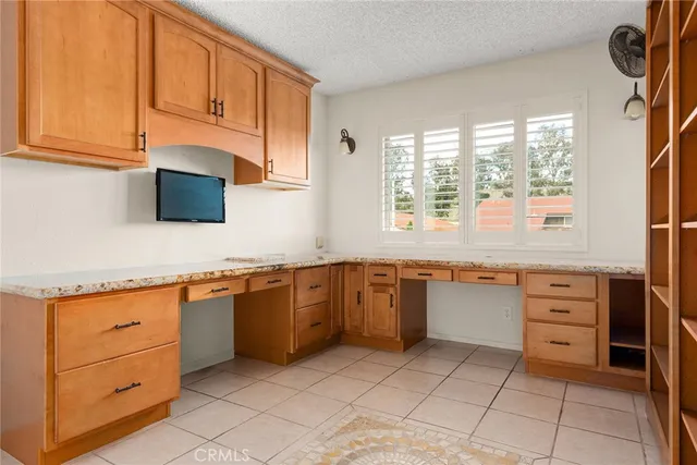 a kitchen with granite countertop a sink window and cabinets