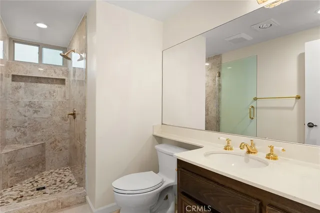 a bathroom with a sink a toilet a shower and a mirror