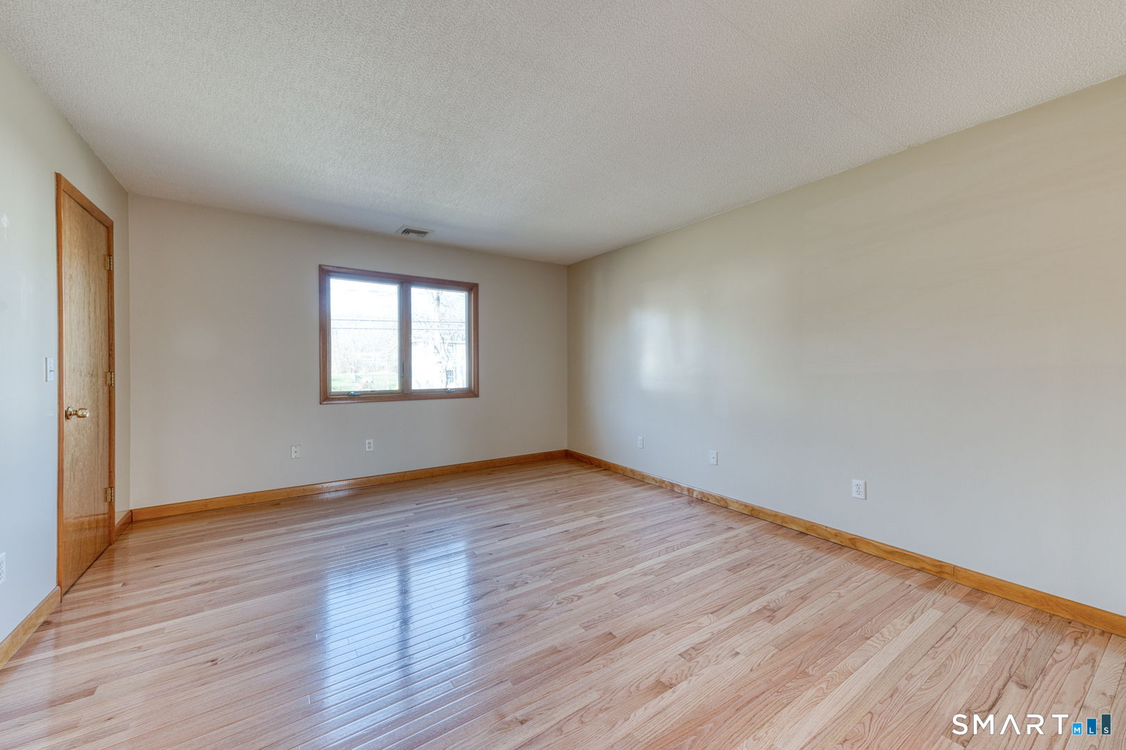 57 4 Rod Road Berlin, CT 06037 - Photo 13 of 31 a view of an empty room with wooden floor and a window