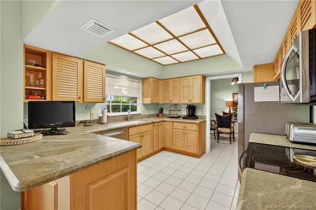 a kitchen with stainless steel appliances granite countertop a stove a sink dishwasher a refrigerator and cabinets with wooden floor