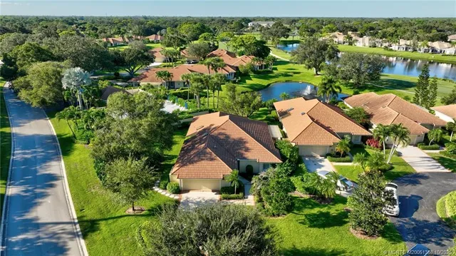 an aerial view of residential houses with outdoor space and trees
