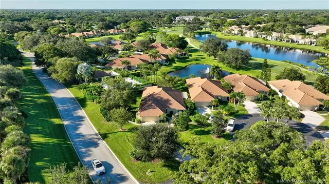 an aerial view of residential houses with outdoor space and trees