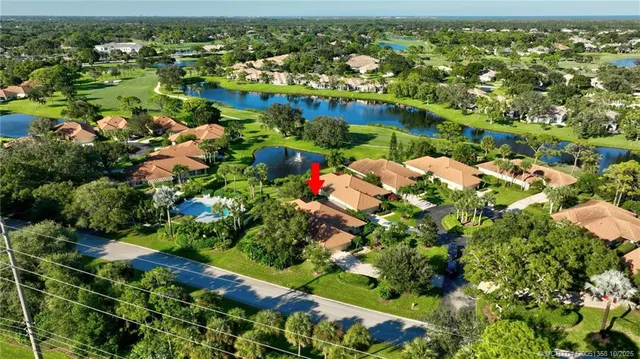 an aerial view of residential houses with outdoor space and trees