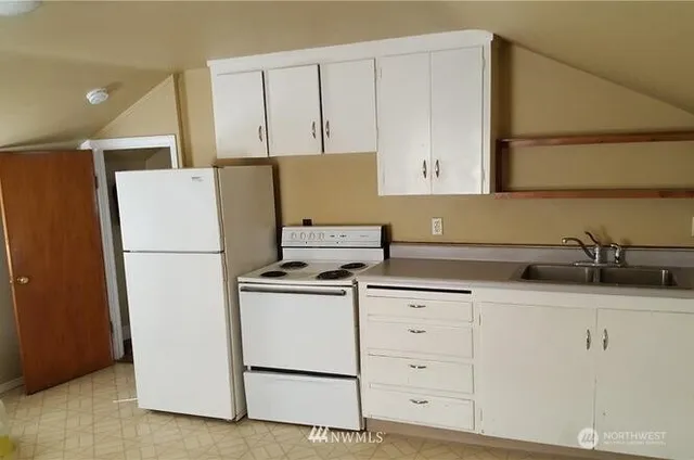 a kitchen with appliances a sink and cabinets