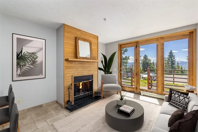 a living room with furniture a large window and a fireplace
