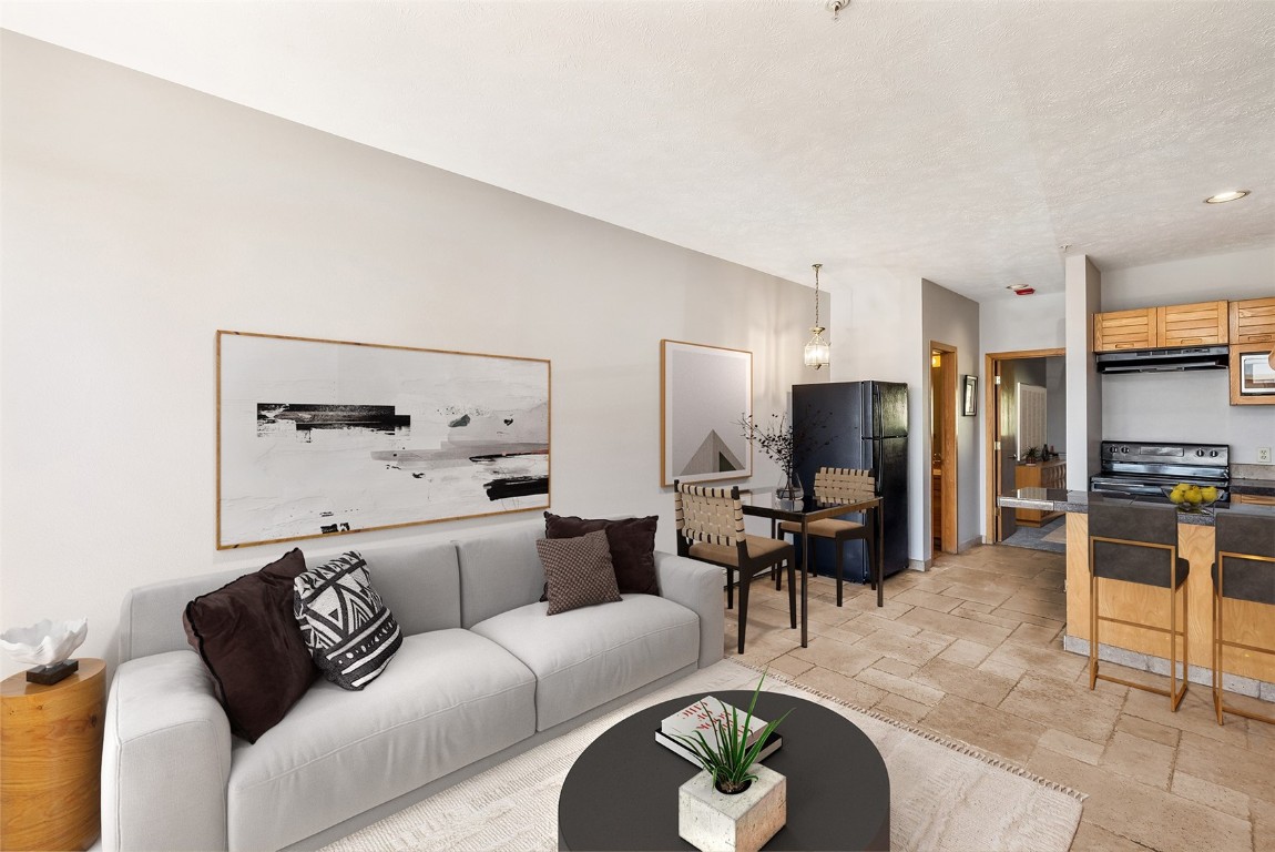 91400 Ryan Gulch Road, Unit 408B Silverthorne, CO 80498 - Photo 2 of 26 a living room with furniture and kitchen view