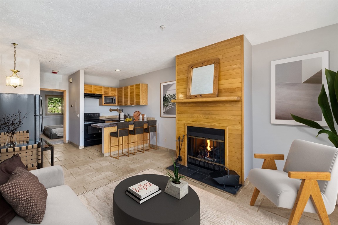 91400 Ryan Gulch Road, Unit 408B Silverthorne, CO 80498 - Photo 3 of 26 a living room with furniture and a fireplace