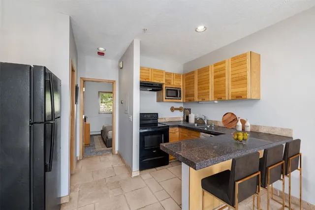 a kitchen with stainless steel appliances granite countertop a stove refrigerator and cabinets