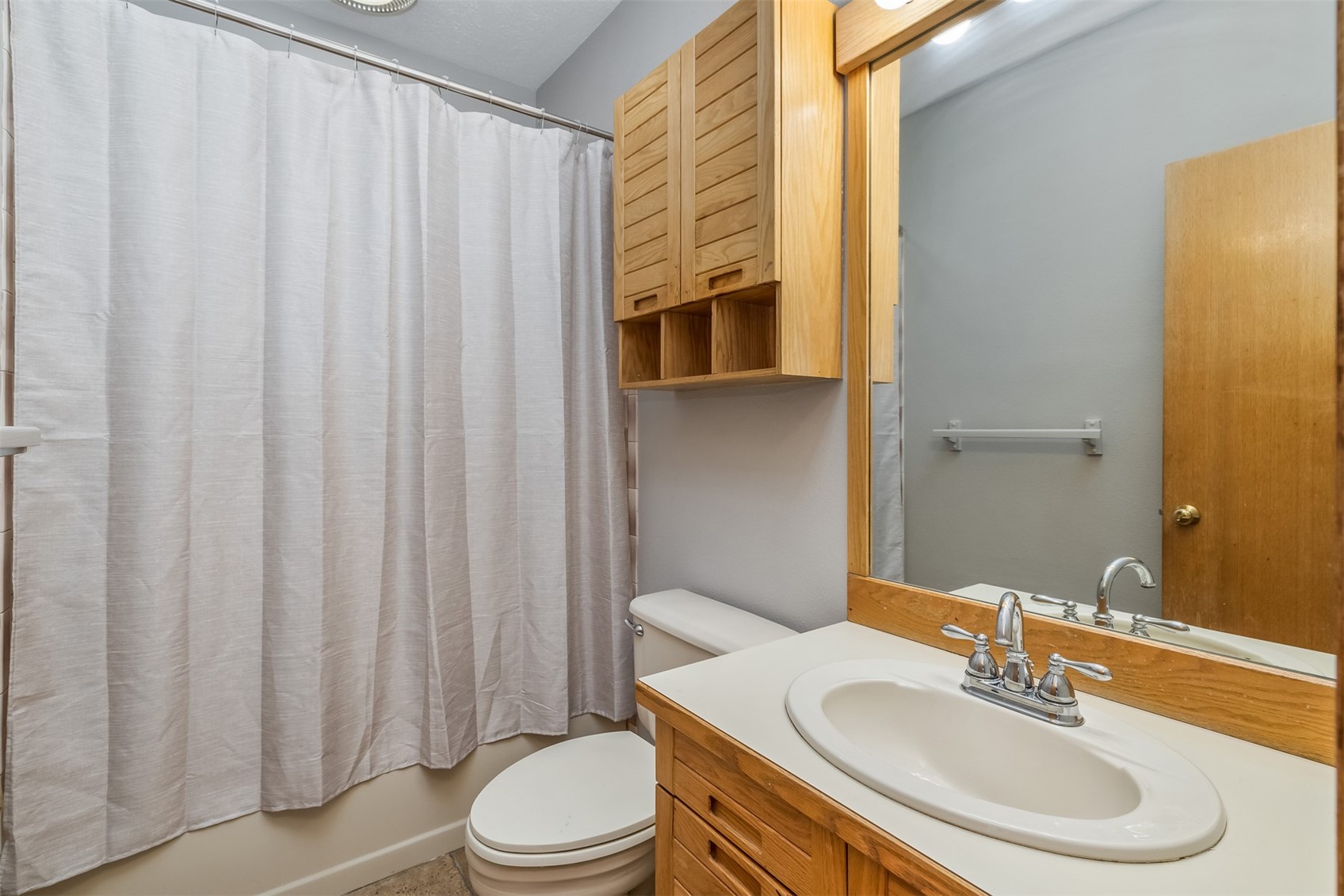 91400 Ryan Gulch Road, Unit 408B Silverthorne, CO 80498 - Photo 5 of 25 a bathroom with a sink a toilet and shower curtain