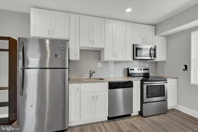 a kitchen with stainless steel appliances a refrigerator and a stove top oven