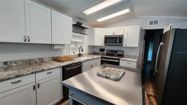 a kitchen with a refrigerator a stove a microwave and cabinets