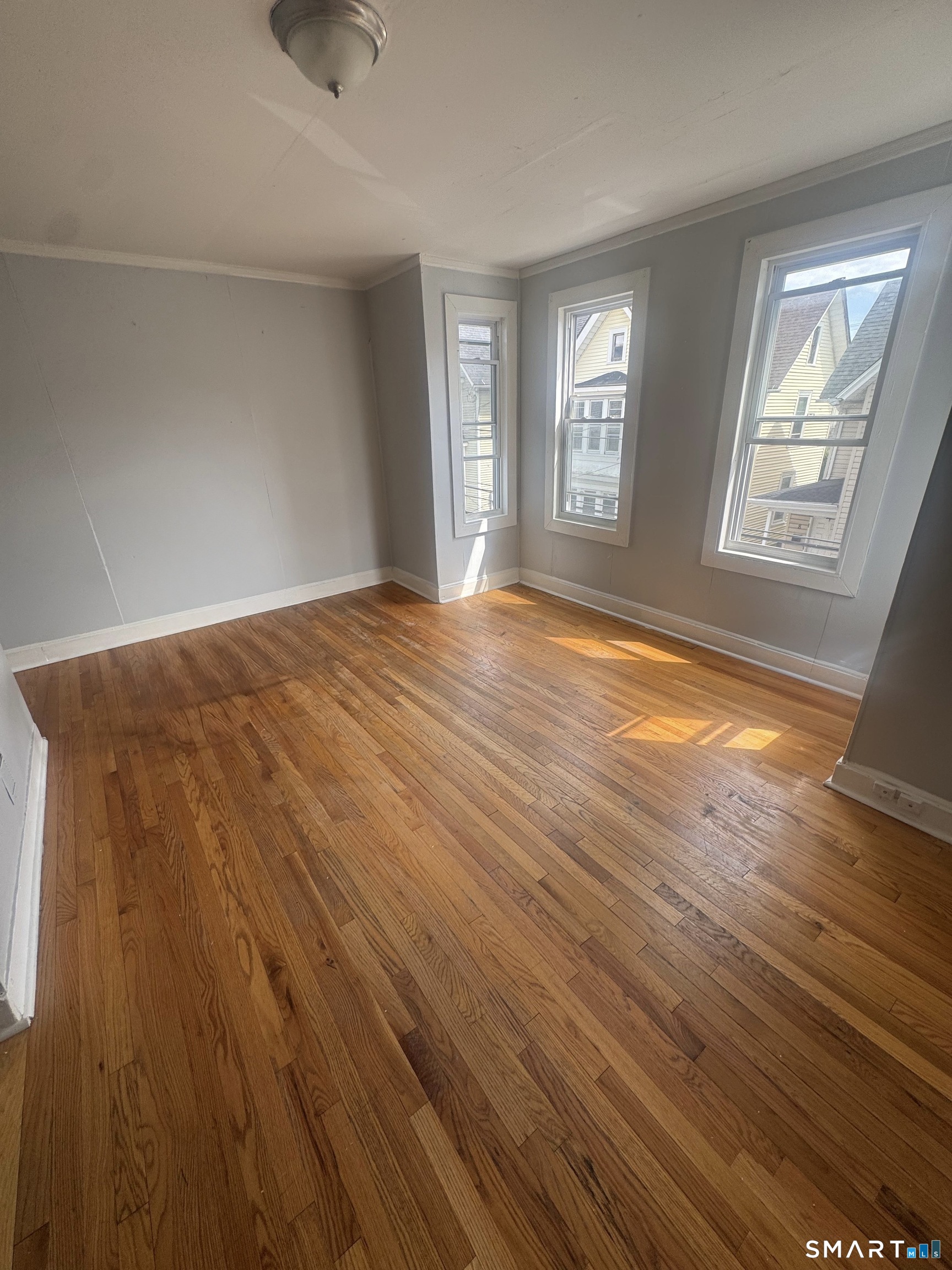7 Armstrong Place Bridgeport, CT 06608 - Photo 2 of 9 wooden floor in an empty room with a window