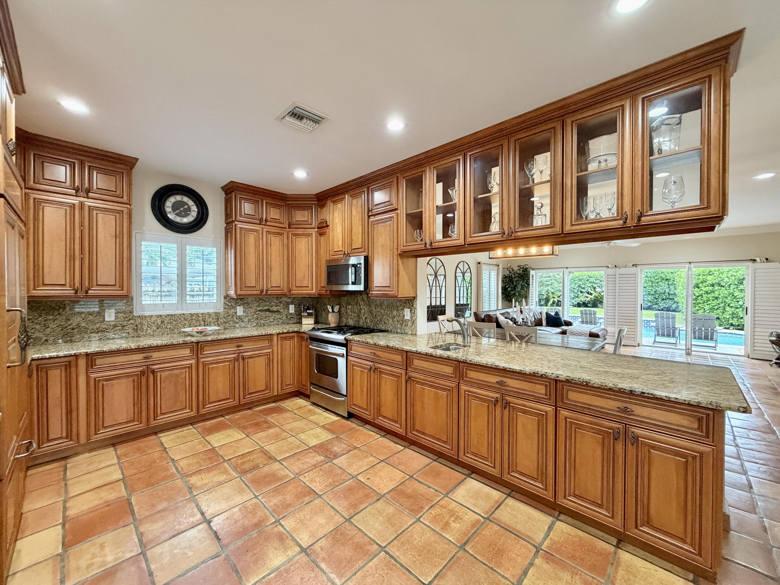 6401 Travis Road West Palm Beach, FL 33406 - Photo 22 of 99 a large kitchen with stainless steel appliances granite countertop a large window and a sink