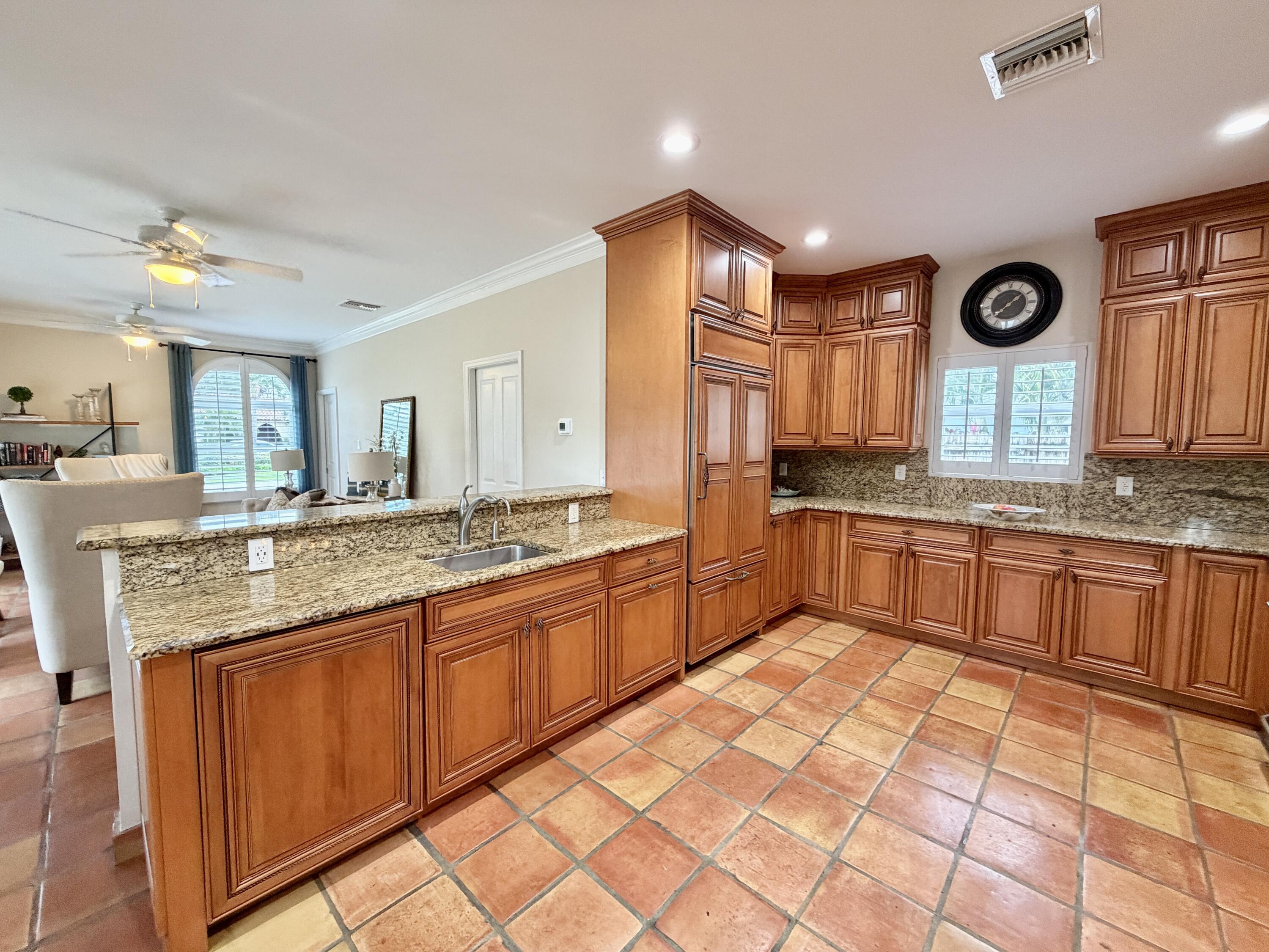 6401 Travis Road West Palm Beach, FL 33406 - Photo 23 of 99 a large kitchen with granite countertop a sink and cabinets