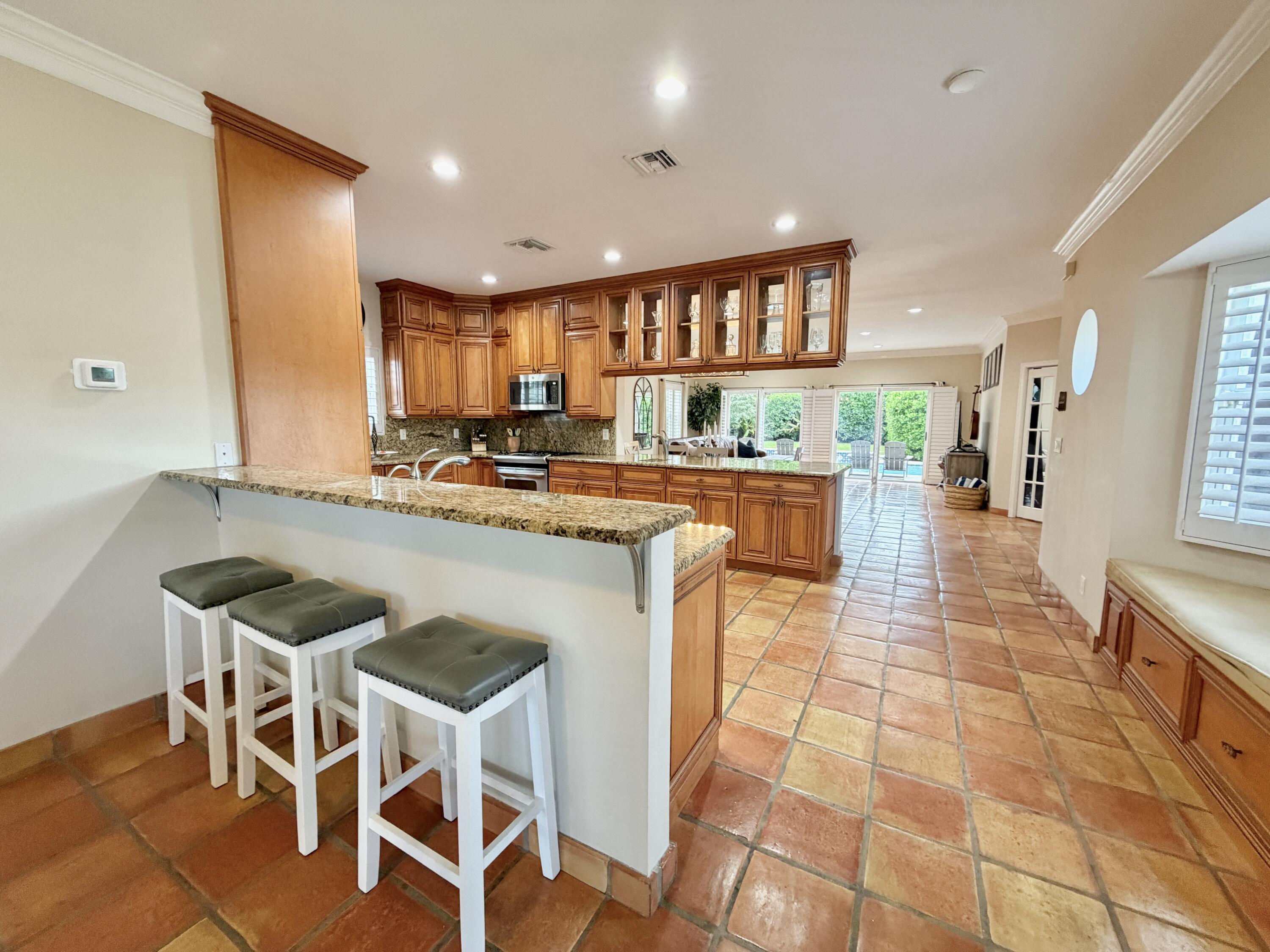 6401 Travis Road West Palm Beach, FL 33406 - Photo 27 of 99 a kitchen with stainless steel appliances granite countertop a stove a sink and a refrigerator