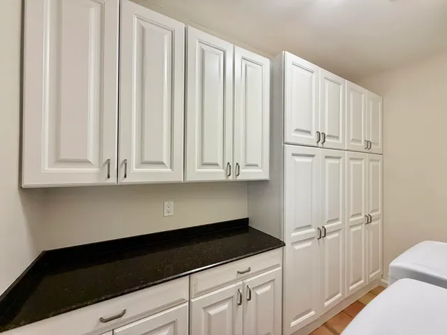 a bathroom with a granite countertop double vanity sink and a mirror