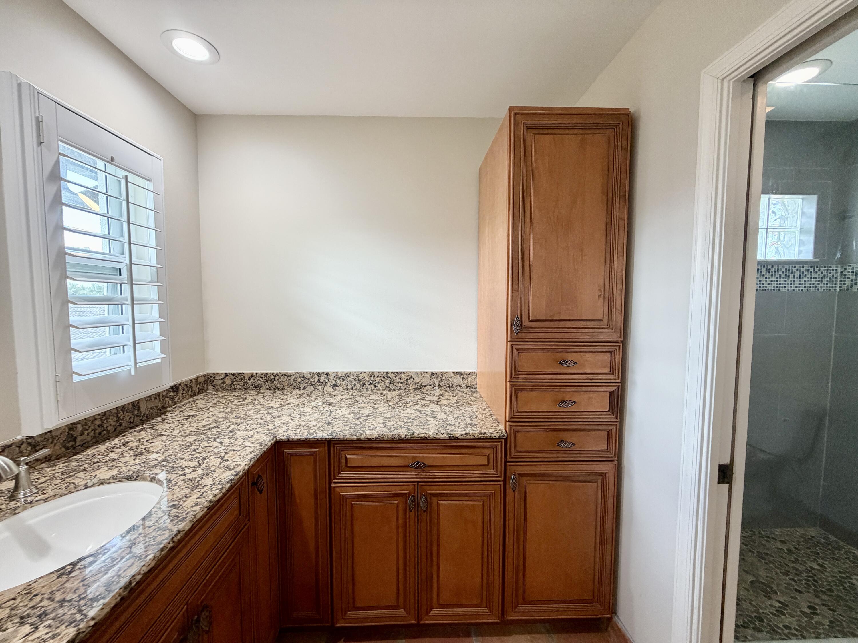 6401 Travis Road West Palm Beach, FL 33406 - Photo 72 of 99 a bathroom with a granite countertop sink and a mirror