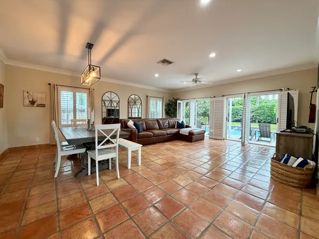 a dining hall with stainless steel appliances kitchen island granite countertop a dining table chairs and view of living room