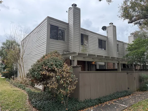 a view of a house with a yard and potted plants