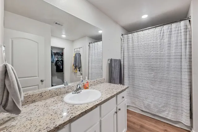 a bathroom with a granite countertop sink and a mirror